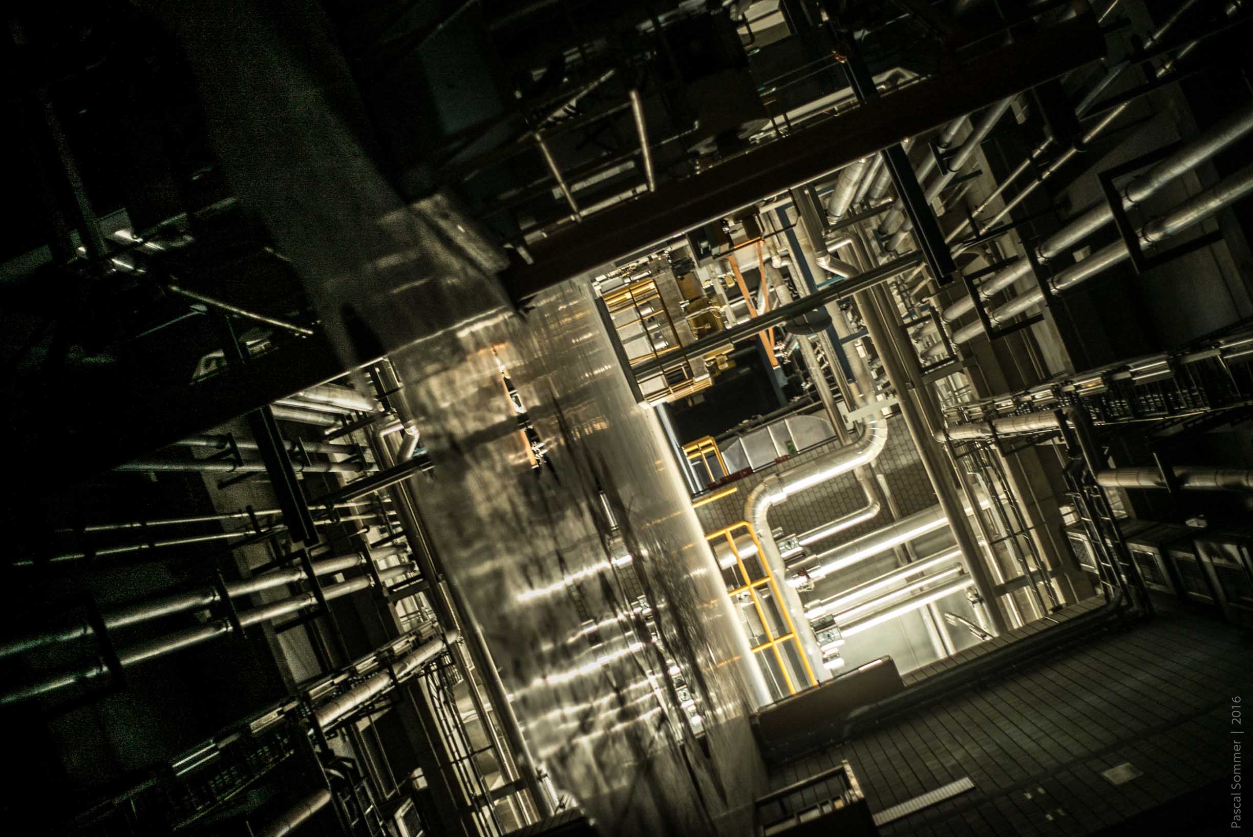 This photo was taken at an angle through a long corridor with puddles on the floor. Upwards is to the upper right.